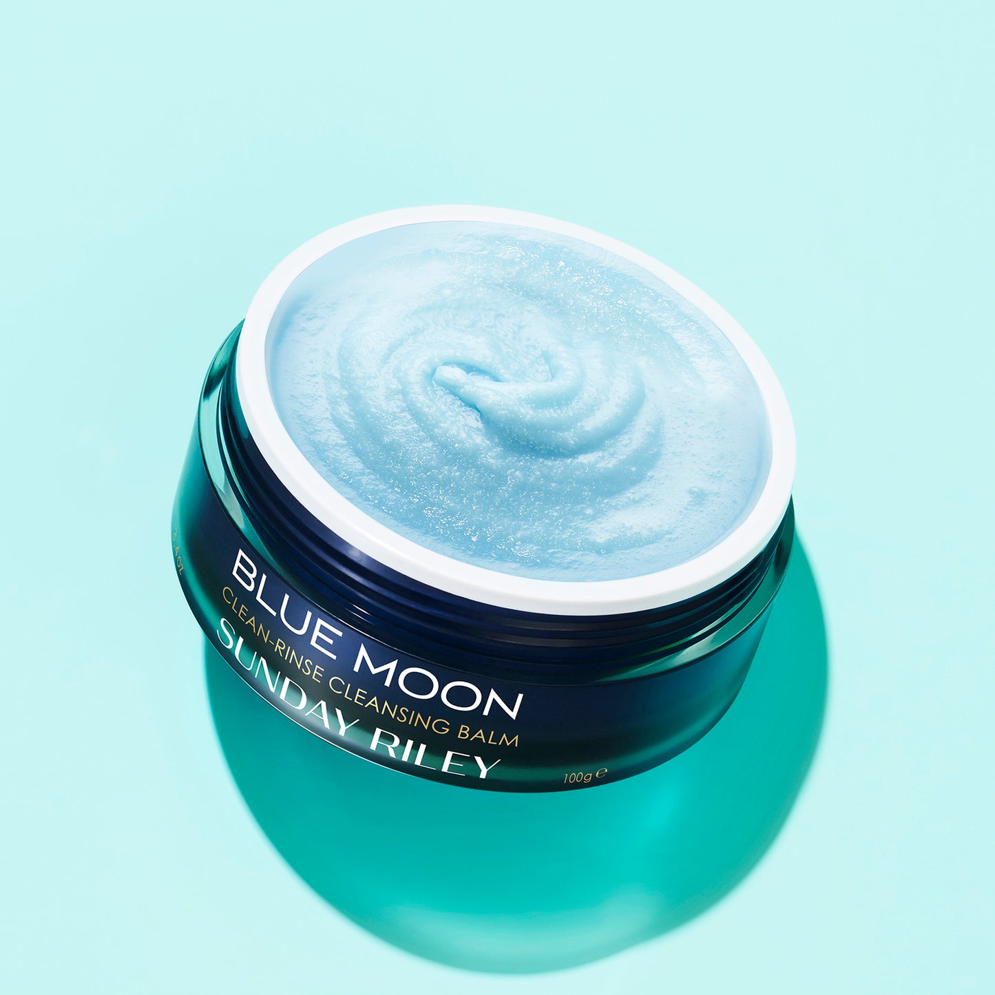 Blue Moon Cleasing Balm, dark blue open jar showing light blue sugar like balm.