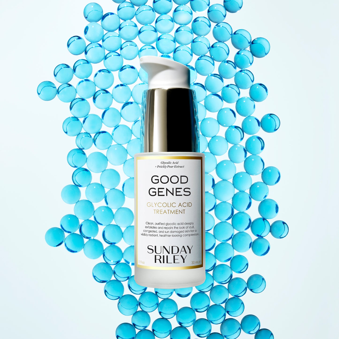 A Good Genes Glycolic frosted glass bottle with gold cap and white pump in a 30 mL bottle lay down on light blue marbles.