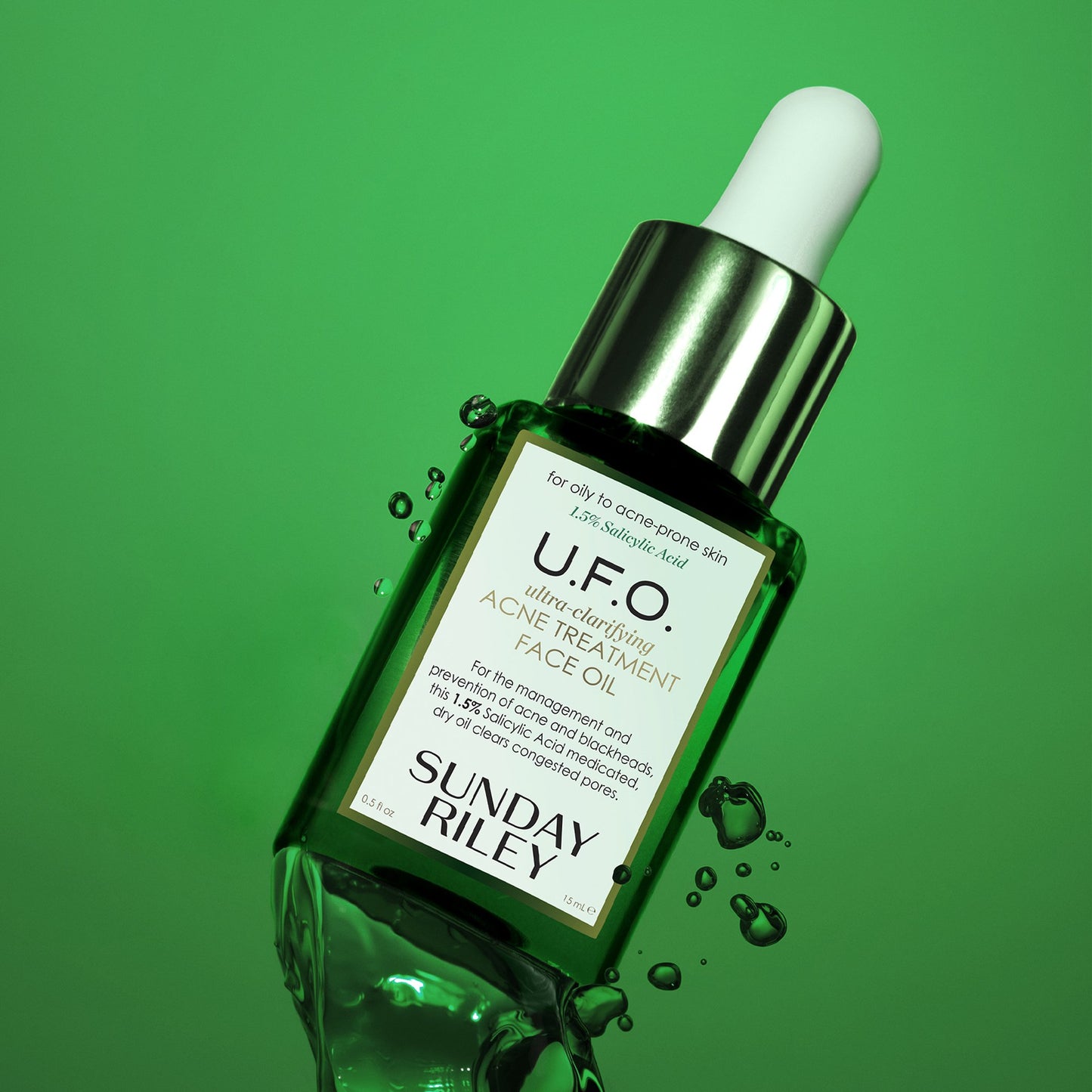 U.F.O. Acne Treatment Face Oil dive in a green oil background with  liquid movement on the bottom