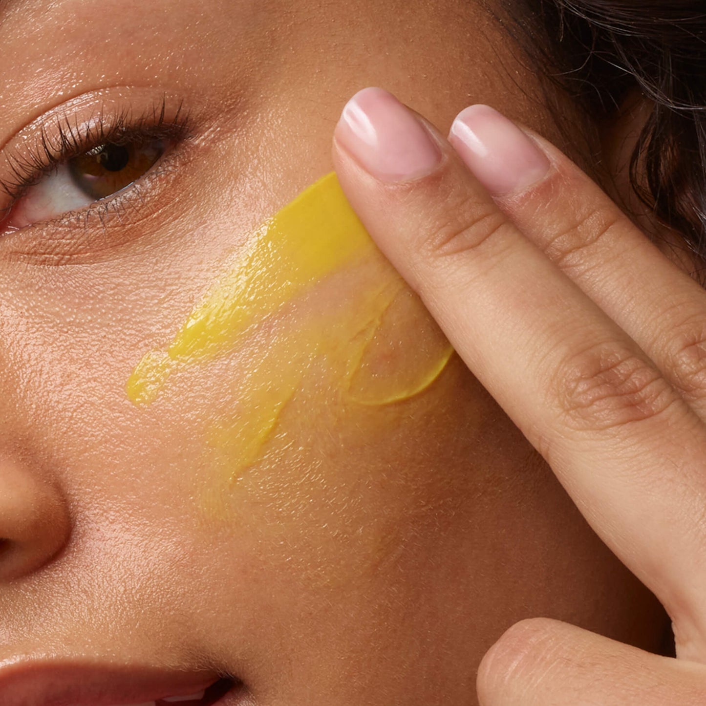 Face model applying C.E.O. Afterglow Brightening Vitamin C Cream to her face