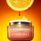 C.E.O. Afterglow jar in front of a orange background with a slice of orange above the jar with dripping juices