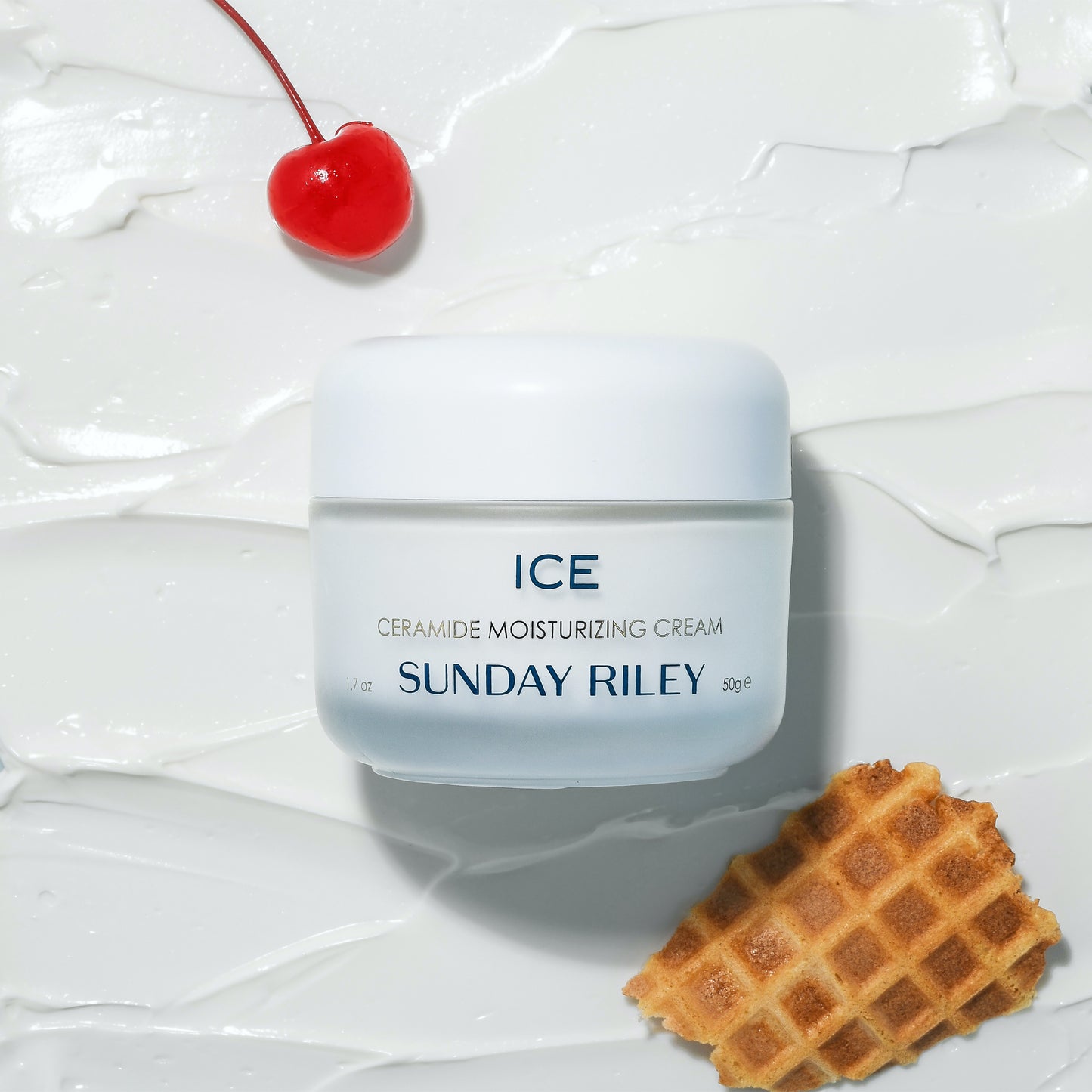 ICE Ceramide Moisturizing Cream laying over the goop with a chery on top left and a piece of ice cream cone on the botton right