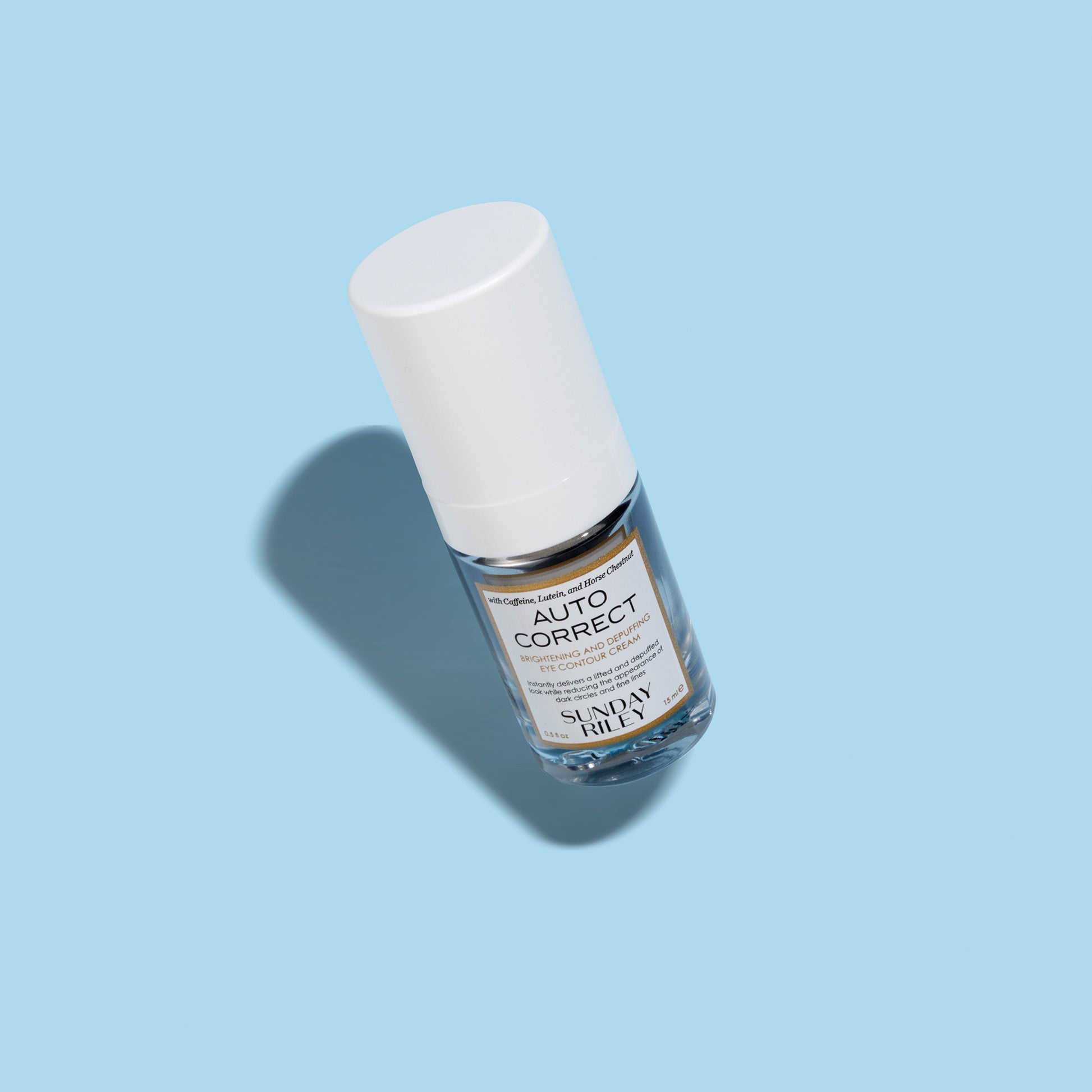 Pastel Blue background, Autocorrect eye cream product image, silver bottle with white cap